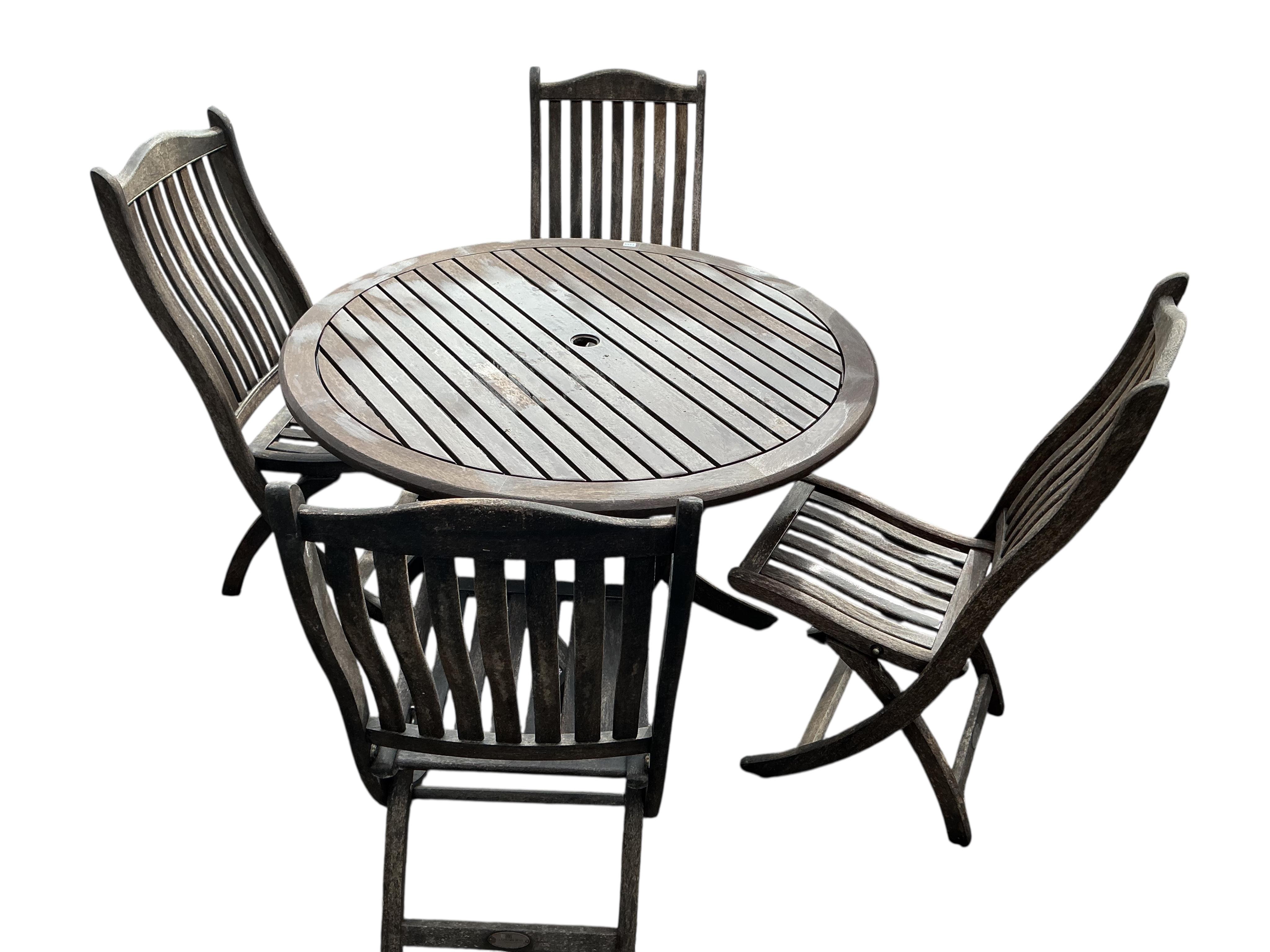 An Alexander rose folding teak garden table, diameter 120cm, height 74cm, and four chairs